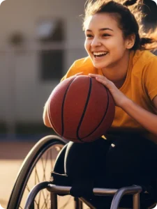 A girl in a wheelchair joyfully engages a basketball game.