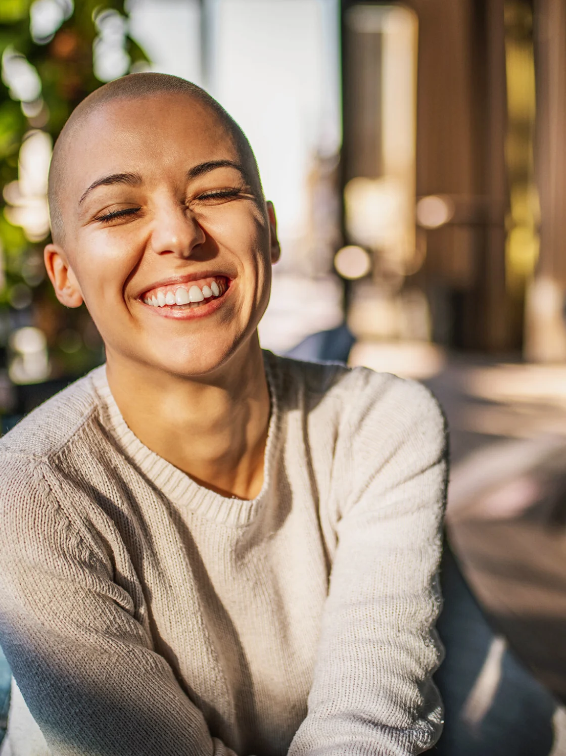 A lady sits with a radiant smile and bright eyes, showing pure happiness and contentment.